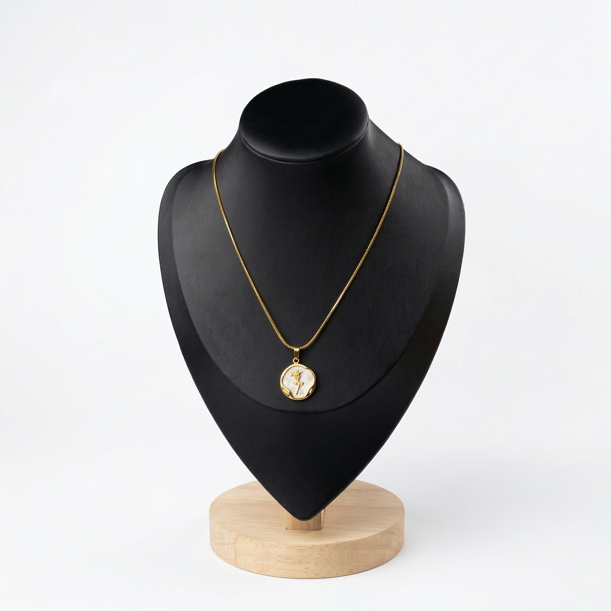Gold rose coin necklace with white mother-of-pearl inlay and organic gold frame displayed on a black jewelry bust.